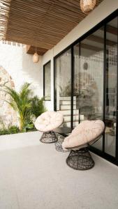 two chairs and a glass table on a patio at Casa Amani 3BR Mediterranean w Pool Near Seminyak in Kerobokan