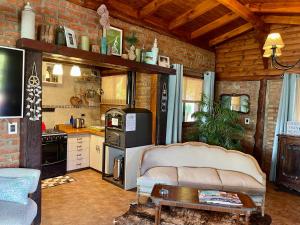 a kitchen with a couch and a table in a room at One Cabañas Malva in Los Antiguos