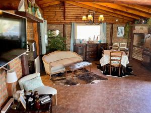 a living room with a couch and a table and chairs at One Cabañas Malva in Los Antiguos
