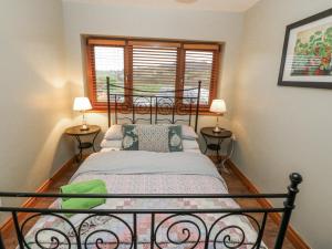 um quarto com uma cama preta e 2 candeeiros em Lough Cluhir Cottage em Myross