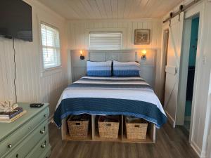een kleine slaapkamer met een bed en twee manden bij Egret in Holden Beach
