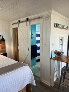 een slaapkamer met een bed, een bureau en een tafel bij Egret in Holden Beach