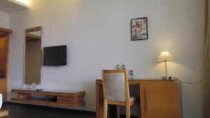 a room with a desk with a television and a chair at Mountain Retreat Kodai in Kodaikānāl