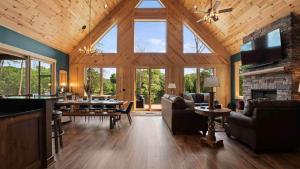 Luxe Lakefront Retreat w Pool Hot Tub Theater Private Dock Sleeps 20 في ليك نورمان أوف كاتاوبا: غرفة معيشة كبيرة مع موقد حجري