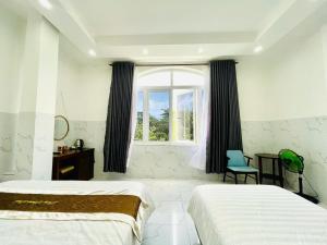 コンダオにあるHưng Khánh Hotelのベッド2台と窓のある寝室 +77枚の写真