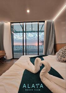 ein Schlafzimmer mit einem Bett mit zwei Schwänen darauf in der Unterkunft Alaya Beach Club 
