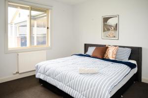 een slaapkamer met een bed en een raam bij Alaaya in Wallan