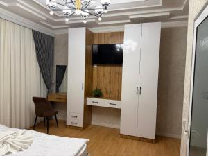 纳曼干Milliy Hotel - Namangan city的一间卧室配有一个大型白色橱柜,内配电视
