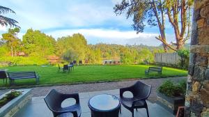 a patio with a table and chairs in a park at Mountain Retreat Kodai in Kodaikānāl