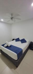 a bedroom with a bed with blue sheets and a ceiling at Condominio, Bello Horizonte Plaza, Santa Marta. in Santa Marta