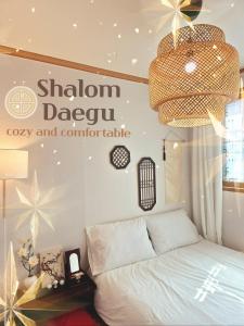 a bedroom with a bed and a chandelier at 샬롬 스테이 in Daegu