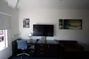 a room with a desk and a television on a wall at Hotel Nelson in Tijuana