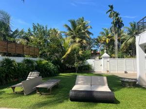 a yard with two chairs and a bench and a table at Star Light Tropical Villa in Bentota