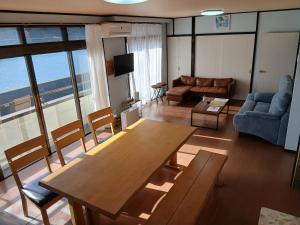 a living room with a table and a couch at ゲストハウスMoana 那珂湊おさかな市場徒歩5分,9名可,BBQ可 in Hitachinaka