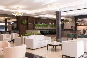 Mallberry Suites Business Hotel في Pontud: لوبي واثاث ابيض وبار