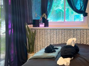 Dos peluches tumbados en una cama cerca de una ventana en Three Palms - Beach Front Tiny House by SP Villa, en Nathon Bay 33 fotos más