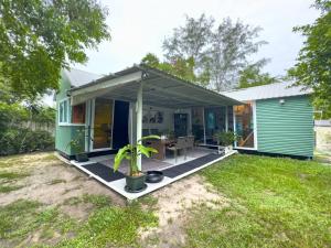 Casa verde con porche con mesa en Three Palms - Beach Front Tiny House by SP Villa, en Nathon Bay