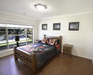 a bedroom with a bed and a large window at Popular Grand Villa Shepparton in Shepparton