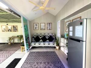 Una sala de estar con un sofá y un ventilador de techo. en Three Palms - Beach Front Tiny House by SP Villa, en Nathon Bay