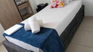 a bed with two rolled towels on it at Condominio, Bello Horizonte Plaza, Santa Marta. in Santa Marta +26 photos