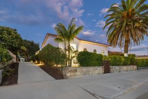 a white house with palm trees and a sidewalk at Casa Castillo - Boutique Suites in Downtown Santa Barbara in Santa Barbara