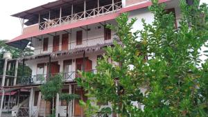 a tall building with trees in front of it at Habitación Casa Wayllu Pucallpa in Pucallpa