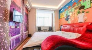 Super 8 Hotel Jinan Railway Station Square في جينان: غرفة نوم بسرير كبير مع أريكة حمراء