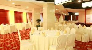a banquet hall with white tables and white chairs at Best Western Tianjin Juchuan Hotel in Binhai