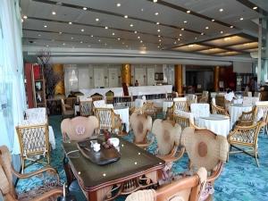 a dining room with tables and chairs in a room at Zhengzhou Airport Hotel in Zhengzhou Xinzheng International AIrport