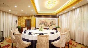a large room with a table and chairs in it at Zhengzhou Airport Hotel in Zhengzhou Xinzheng International AIrport