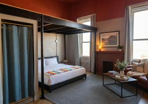 a bedroom with a canopy bed and a fireplace at The Well Hotel & Taproom in Trinidad