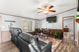 uma sala de estar com um sofá de couro e uma ventoinha de tecto em The Country Haven em Huntsville