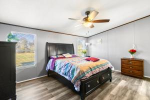 um quarto com uma cama e um ventilador de teto em The Country Haven em Huntsville
