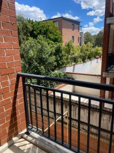 a balcony with a black railing and a brick building at Platform One Guildford in Guildford