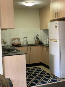a kitchen with a white refrigerator and a sink at Platform One Guildford in Guildford