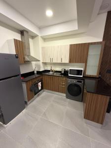 een grote keuken met houten kasten en een vaatwasser bij Modern & Elegant Fully Equipped Apartment in Sār