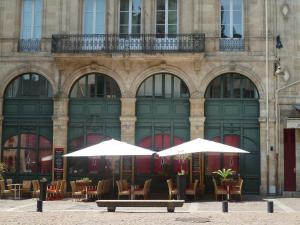 two white umbrellas in front of a building at LES TROIS CHANDELIERS un petit paradis en plein centre ville in Bordeaux