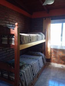 due letti a castello in una stanza con finestra di Cabañas Yarel ad Alpa Corral