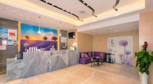 Lavande Hotel Wuhan Jianghan Road Subway Station في ووهان: لوبى مع أريكة أرجوانية وطاولة