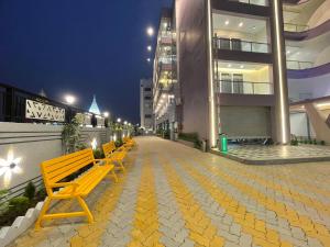 a row of yellow benches in front of a building at Parth King Resort Tarapith A Unit of Prattay Infratech Private Limited in Tarapith