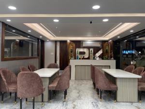 a restaurant with two tables and chairs and a counter at Parth King Resort Tarapith A Unit of Prattay Infratech Private Limited in Tarapith