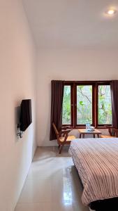 Un dormitorio con una cama y una ventana grande. en Kosasih 1919 A Dutch-Retro House, en Banyuwangi 36 fotos más