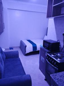 MeruZayana staycation的一间带床、沙发和炉子的小房间