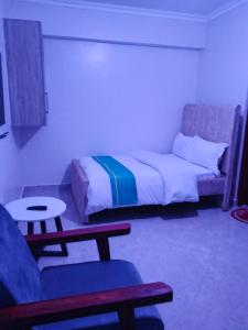 MeruZayana staycation的一间卧室，里面有一张床、一张沙发和一张桌子