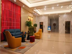 Borrman Hotel Zhanjiang Shimao Building High-speed Railway Station في Tchia-k'am: ردهة بها كراسي وطاولات في مبنى