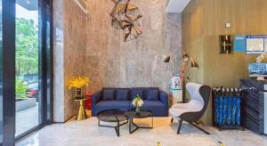 a living room with a blue couch and a table at Echarm Hotel Nanjing Jiangning Tianyin Avenue Metro Station in Fangshan