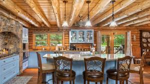 Bigwood Cabin Retreat Hot Tub Game Room Firepit Lounge Private Yard في Long Pond: مطبخ بأسقف خشبية وجزيرة كبيرة مع كراسي بار