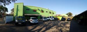 a parking lot with cars parked in front of a building at Hotel Figueira Palace in Dourados