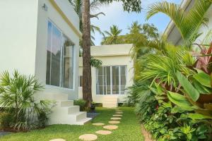 a white house with palm trees and a walkway at Bright Sanctuary in Ko Phangan +14 photos