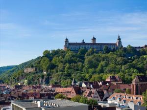 a town on top of a hill with a castle at Mercure Hotel Würzburg am Mainufer in Würzburg
